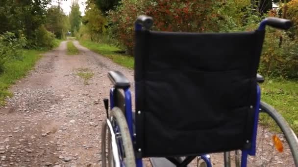 Lege rolstoel op de weg wachtend op patiëntenzorg. Rolstoel voor mensen met een handicap geparkeerd buiten. Toegankelijk voor personen met een handicap. Gezondheidszorg medisch concept. — Stockvideo