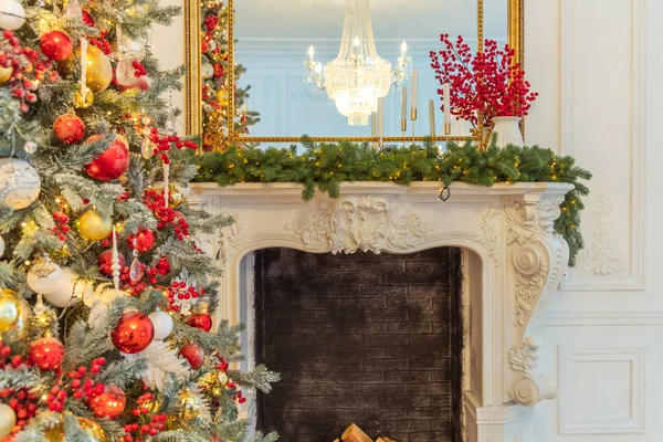 经典的圣诞装饰室内装饰，新年树与红色和金色装饰。现代白色古典风格室内设计公寓与壁炉和圣诞树。平安夜在家里. — 图库照片
