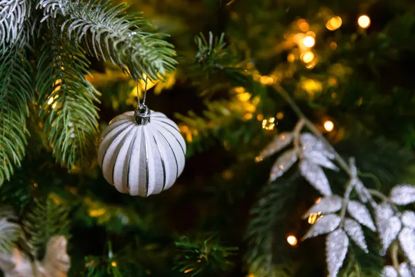 Albero di Natale decorato classico Anno nuovo. Albero di Natale con decorazioni in bianco e argento, ornamenti giocattolo e palla. Moderno appartamento di design d'interni in stile classico. Vigilia di Natale a casa. — Foto Stock