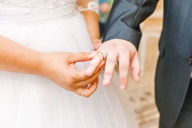 Gelin ve damat evlilik alyans elle. Gelin el alyans damat parmağında koyarak. Bildirim sevgisi, Bahar. Düğün kartı tebrik. Düğün günü anlar töreni detayları.