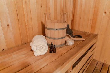 Geleneksel eski Rus hamamı SPA konsepti. Finlandiya sauna saunasında geleneksel sauna aksesuarları ve havlunun aromalı yağ kepçesi kullanılmış. Rahatlayın köy banyosu konsepti.