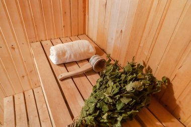 Geleneksel eski Rus hamamı SPA konsepti. İçişleri, geleneksel sauna aksesuarlarıyla Finlandiya sauna sauna saunası havlu süpürge kepçesi kepçesiyle dolu. Rahatlayın köy banyosu konsepti.