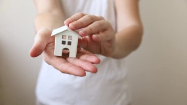 Beyaz arka planda izole edilmiş oyuncak model evi tutan kadın. Gayrimenkul ipoteği sigorta hayali ev konsepti. Kiralık ev, aile hayatı, iş yeri gayrimenkul teklifi.