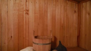 Geleneksel eski Rus hamamı SPA konsepti. Finlandiya sauna saunasında geleneksel sauna aksesuarları ve havlunun aromalı yağ kepçesi kullanılmış. Rahatlayın köy banyosu konsepti.