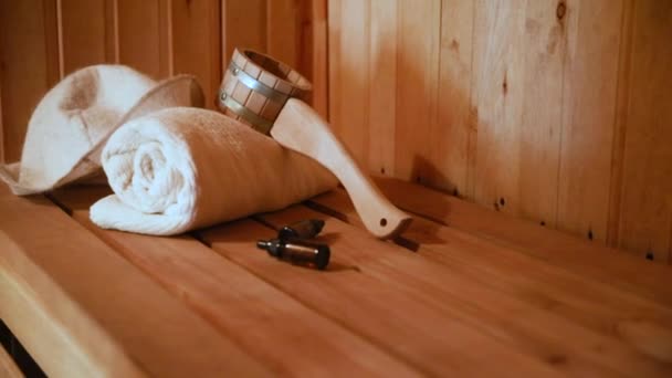 Geleneksel eski Rus hamamı SPA konsepti. Finlandiya sauna saunasında geleneksel sauna aksesuarları ve havlu yağı kepçesi kullanılmış. Rahatlayın köy banyosu konsepti. — Stok video