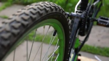 Bisiklet tamircisi dışarıdaki bisiklet tamirhanesinde tamirci bekliyor. Bisiklet tekerleği incelemeye hazır, modern bisiklet şanzıman sistemini tamir ediyor. Bisiklet bakımı, spor mağazası konsepti.