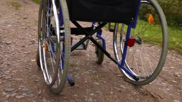 Empty wheelchair standing on road waiting for patient services. Wheel chair for people person with disability parked outdoor. Accessible for person with disability. Health care medical concept. — Stock Video