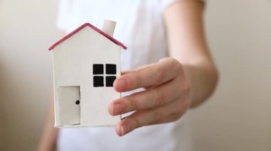 Beyaz arka planda izole edilmiş oyuncak model evi tutan kadın. Gayrimenkul ipoteği sigorta hayali ev konsepti. Kiralık ev, aile hayatı, iş yeri gayrimenkul teklifi.