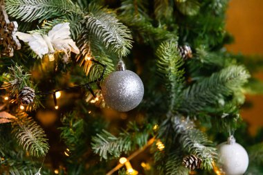 Klasik Noel süslemeli yılbaşı ağacı. Noel ağacı, gümüş süslemeler, süsler, oyuncak ve top. Modern klasik stil iç tasarım dairesi. Evde Noel arifesi.