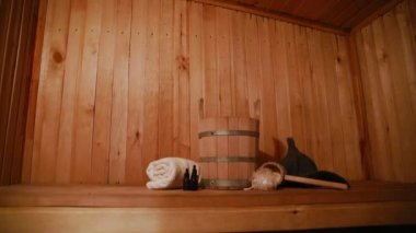 Geleneksel eski Rus hamamı SPA konsepti. Finlandiya sauna saunasında geleneksel sauna aksesuarları ve havlunun aromalı yağ kepçesi kullanılmış. Rahatlayın köy banyosu konsepti.