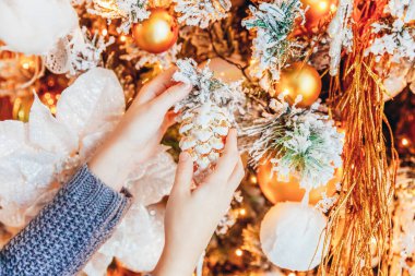 Noel arifesinde evde Noel ağacı süsleyen kız ellerini kapat. Küçük çocuk kış dekorasyonlu, açık renk yatak odasında. Noel Yeni Yıl Kutlama Konsepti Zamanı.