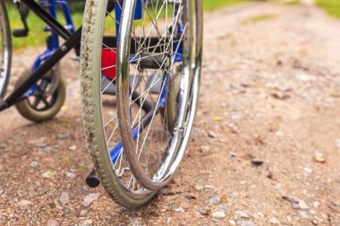 Yoldaki boş tekerlekli sandalye hasta hizmetlerini bekliyor. Dışarıda park etmiş engelli insanlar için tekerlekli sandalye. Özürlü insanlar için erişilebilir. Sağlık hizmeti tıbbi konsepti.