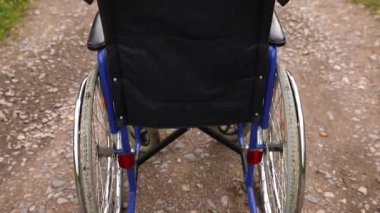 Yoldaki boş tekerlekli sandalye hasta hizmetlerini bekliyor. Dışarıda park etmiş engelli insanlar için tekerlekli sandalye. Özürlü insanlar için erişilebilir. Sağlık hizmeti tıbbi konsepti.