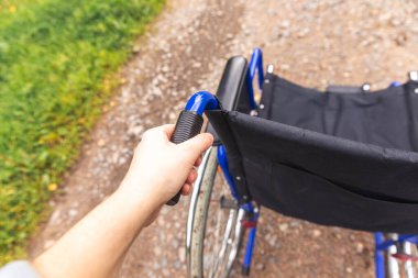 Hastanenin parkında hasta hizmetlerini bekleyen boş bir tekerlekli sandalye. Dışarıda park etmiş engelliler için tekerlekli sandalye. Özürlü insanlar için erişilebilir. Sağlık hizmeti tıbbi konsepti.