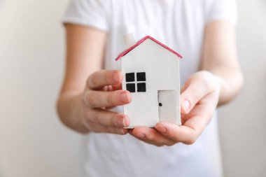 Beyaz arka planda izole edilmiş oyuncak model evi tutan kadın. Gayrimenkul ipoteği sigorta hayali ev konsepti. Kiralık ev, aile hayatı, iş yeri gayrimenkul teklifi.