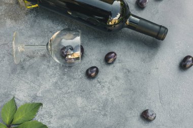 Bir şişe kırmızı şarap, yeşil üzüm, şarap kadehi ve olgun üzümlü eskimiş taş masa arkaplanı. Metin için üst görünüm kopyalama alanı. Şarap dükkanı şarap dükkanı ya da şarap tatma konsepti