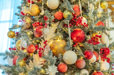 Klasik Noel yılbaşı ağacı kırmızı ve beyaz süsleme oyuncakları ve top ile süslenmiş. Modern klasik stil iç tasarım dairesi. Evde Noel arifesi