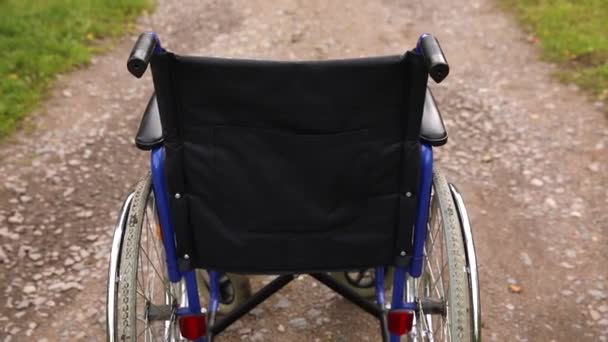 Pusty wózek inwalidzki stojący na drodze, czekający na usługi dla pacjentów. Krzesełko dla osób niepełnosprawnych zaparkowane na zewnątrz. Dostępny dla osób niepełnosprawnych. Koncepcja medyczna opieki zdrowotnej. — Wideo stockowe