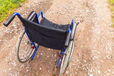 Yoldaki boş tekerlekli sandalye hasta hizmetlerini bekliyor. Dışarıda park etmiş engelli insanlar için tekerlekli sandalye. Özürlü insanlar için erişilebilir. Sağlık hizmeti tıbbi konsepti.