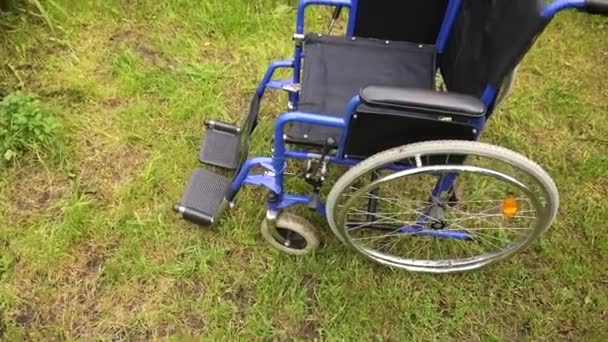 Пустое инвалидное кресло, стоящее в больничном парке и ожидающее обслуживания пациентов. Коляска для инвалида, припаркованная на улице. Доступно для людей с ограниченными возможностями. Медицинская концепция. — стоковое видео