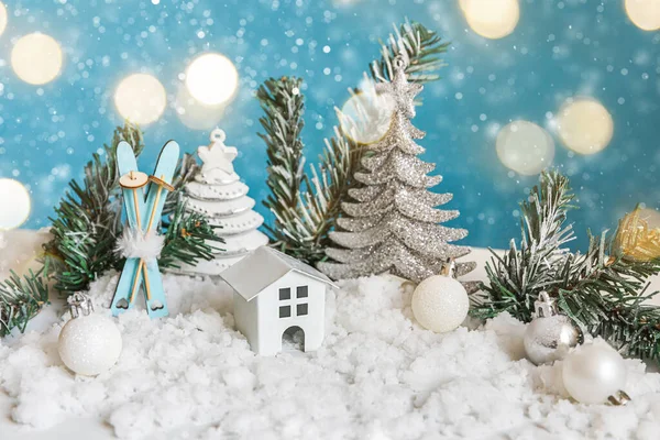 성탄절에는 성탄절을 배경으로 한다. 장난감으로 만들어 진 집 과 겨울 장식용 장식물은 파란색 배경에 눈 과 잘 사용되지 않는 복장등으로 장식되어 있다. 가정에서 크리스마스를 보내는 모습. — 스톡 사진