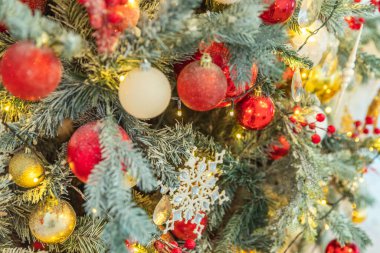 Klasik Noel yılbaşı ağacı kırmızı altın ve beyaz süsleme oyuncakları ve balo ile süslenmiş. Modern klasik stil iç tasarım dairesi. Evde Noel arifesi.