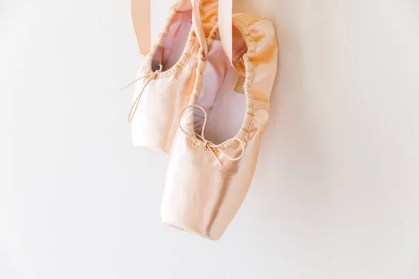 Nuevos zapatos de ballet beige pastel con cinta de satén aislada sobre fondo blanco. Bailarina de puntas clásicas para entrenamiento de baile. Escuela de ballet, Copiar espacio — Foto de Stock