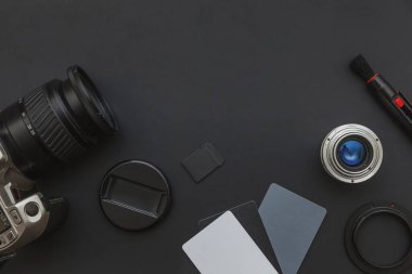 DSR kamera sistemi, kamera temizleme seti, siyah masa arka planında lens ve kamera aksesuarları olan fotoğrafçı işyeri. Hobi seyahat fotoğrafçılık konsepti. Düz görünüm kopyalama alanı.