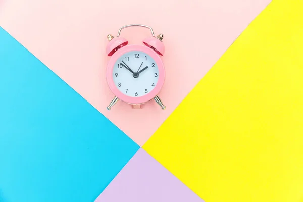 Dering twin bell jam alarm klasik Terisolasi pada biru kuning pastel merah muda Berwarna latar belakang geometris. Istirahat jam waktu kehidupan baik pagi bangun bangun konsep terjaga. Ruang salinan tilikan atas rata. — Stok Foto