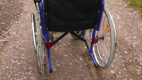 Empty wheelchair standing on road waiting for patient services. Wheel chair for people person with disability parked outdoor. Accessible for person with disability. Health care medical concept. — Stock Video