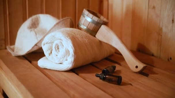 Geleneksel eski Rus hamamı SPA konsepti. Finlandiya sauna saunasında geleneksel sauna aksesuarları ve havlu yağı kepçesi kullanılmış. Rahatlayın köy banyosu konsepti. — Stok video
