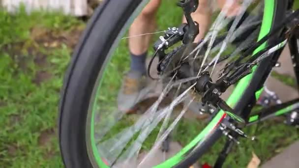 Bike mechanic man repairs bicycle in bicycle repair shop, outdoor. Hand of cyclist bicyclist examines, fixes modern cycle transmission system. Bike maintenance, sport shop concept. — Stock Video
