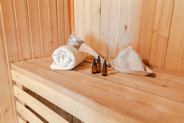 Tradicional velha casa de banho russa SPA Concept. Detalhes do interior sauna finlandesa sala de vapor com acessórios tradicionais sauna conjunto toalha aroma óleo colher feltro. Relaxe conceito de banho aldeia rural. — Fotografia de Stock