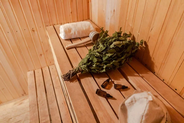 Tradicional antigua casa de baños rusa SPA Concepto. Detalles interiores Cuarto de vapor sauna finlandesa con accesorios de sauna tradicionales conjunto toalla escoba de abedul escoba fieltro. Relajarse pueblo rural concepto de baño. —  Fotos de Stock