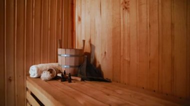 Geleneksel eski Rus hamamı SPA konsepti. Finlandiya sauna saunasında geleneksel sauna aksesuarları ve havlunun aromalı yağ kepçesi kullanılmış. Rahatlayın köy banyosu konsepti.