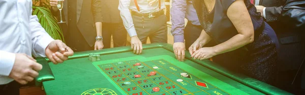 Grupa ludzi za ruletka hazardu tabeli w luksusowym kasynie. Znajomi grają w pokera na stole ruletki z miarką. Vegas gry nocne życie szczęście zwycięskiej koncepcji. Banner. — Zdjęcie stockowe