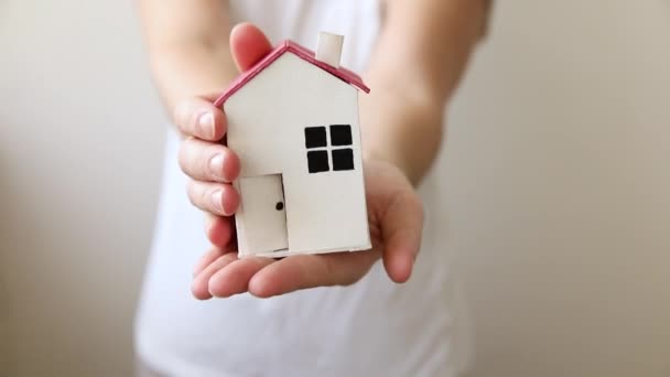 Woman hand holding toy model house isolated on white background. Real estate mortgage property insurance dream home concept. Offer of purchase rental house, family life, business real estate. — Stock Video