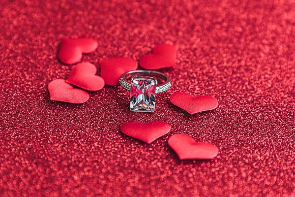 結婚してくれませんか。赤い輝きの背景に結婚指輪と多くの赤い心。婚約結婚の提案結婚式のコンセプト。聖バレンタインデーのポストカード。バレンタインデーのバナー. — ストック写真