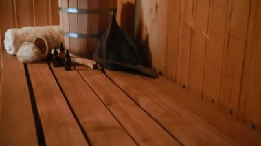 Geleneksel eski Rus hamamı SPA konsepti. Finlandiya sauna saunasında geleneksel sauna aksesuarları ve havlunun aromalı yağ kepçesi kullanılmış. Rahatlayın köy banyosu konsepti.