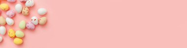 Mutlu Paskalyalar. Tatil için hazırlık. Paskalya şekerli çikolatalı yumurtalar ve jöleli şekerler modaya uygun pembe arka planda izole edilmiş. Basit minimalizm düz üst görünüm kopyalama alanı, pankart