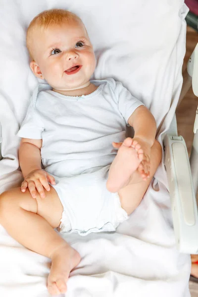 웃는 얼굴로 하얀 배경 카메라를 보고 있는 귀여운 신생아. 아기는 집에 있는 의자에 누울 때놀고 있습니다. 어머니의 행복 한 자녀 개념. — 스톡 사진
