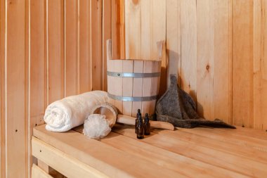 Geleneksel eski Rus hamamı SPA konsepti. Finlandiya sauna saunasında geleneksel sauna aksesuarları ve havlunun aromalı yağ kepçesi kullanılmış. Rahatlayın köy banyosu konsepti.