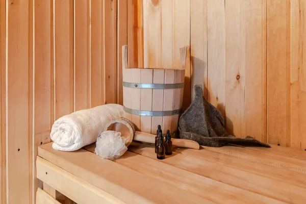 Geleneksel eski Rus hamamı SPA konsepti. Finlandiya sauna saunasında geleneksel sauna aksesuarları ve havlunun aromalı yağ kepçesi kullanılmış. Rahatlayın köy banyosu konsepti. — Stok fotoğraf