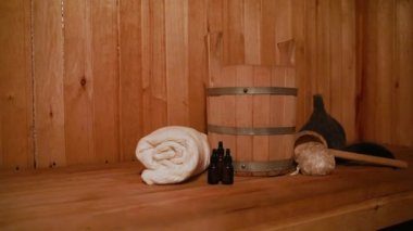 Geleneksel eski Rus hamamı SPA konsepti. Finlandiya sauna saunasında geleneksel sauna aksesuarları ve havlunun aromalı yağ kepçesi kullanılmış. Rahatlayın köy banyosu konsepti.
