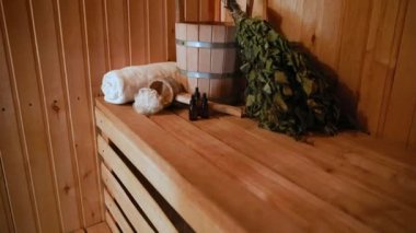 Geleneksel eski Rus hamamı SPA konsepti. İçişleri, geleneksel sauna aksesuarlarıyla Finlandiya sauna sauna saunası havlusu aromalı havluyla döşenmiş. Rahatlayın köy banyosu konsepti.