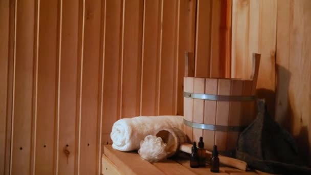 Tradicional velha casa de banho russa SPA Concept. Detalhes do interior sauna finlandesa sala de vapor com acessórios tradicionais sauna conjunto toalha aroma óleo colher feltro. Relaxe conceito de banho aldeia rural. — Vídeo de Stock