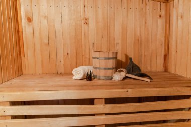 Geleneksel eski Rus hamamı SPA konsepti. Finlandiya sauna saunasında geleneksel sauna aksesuarları ve havlunun aromalı yağ kepçesi kullanılmış. Rahatlayın köy banyosu konsepti.