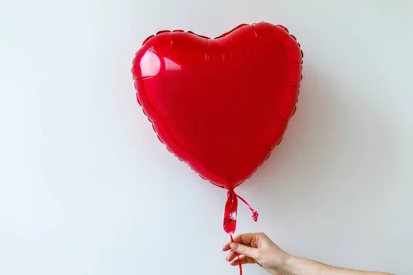 St. Valentines Day concept. Woman hand holding red heart balloon isolated on white background. Person people in love on valentines day gives gift. — Stock Photo, Image