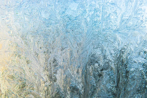 结冰的冬季窗户,冰霜图案质感明亮.圣诞奇迹的象征，抽象的背景。极北低温，冰天雪地冰封在冰封的玻璃上，寒冷的冬季室外气候. — 图库照片