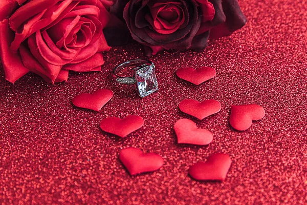 結婚してくれませんか。結婚指輪赤い緋色のバラと赤い輝きの背景に多くの赤い心。婚約結婚の提案結婚式のコンセプト。聖バレンタインデーのポストカード。バレンタインデーのバナー. — ストック写真